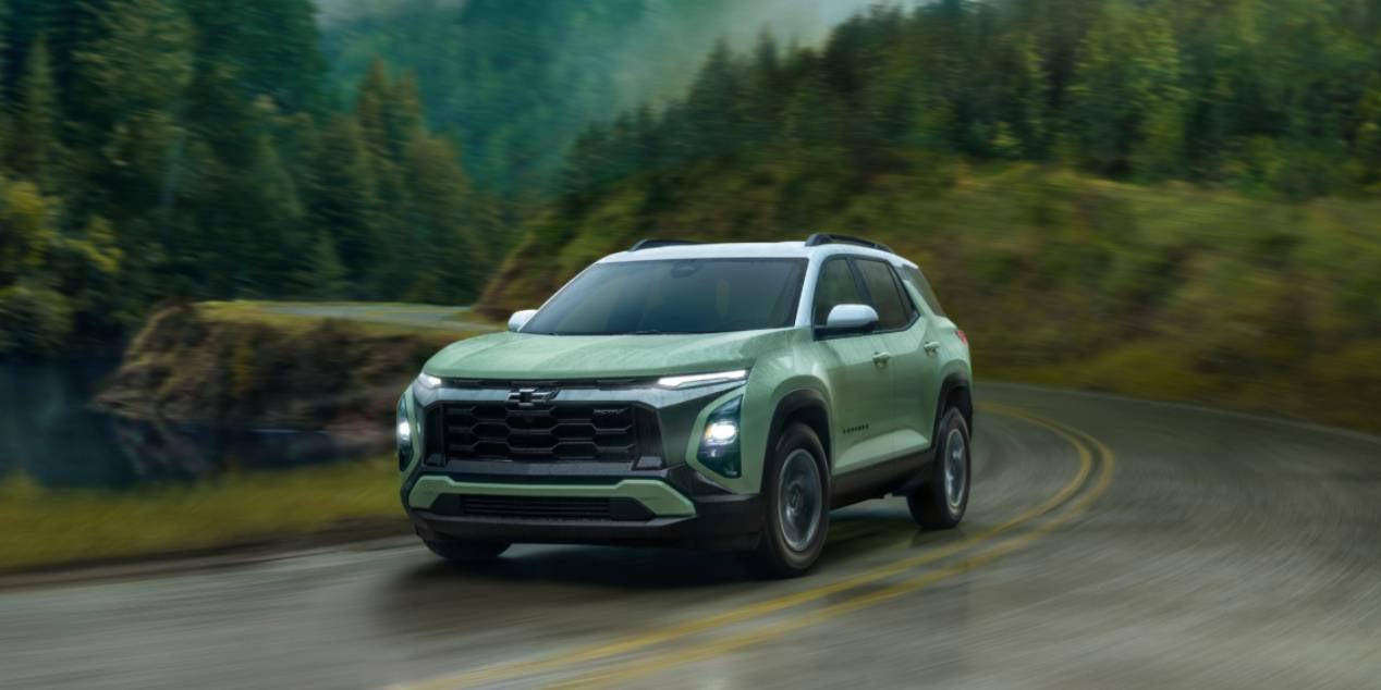 2025 Chevrolet Equinox in green driving in the rain with headlights on