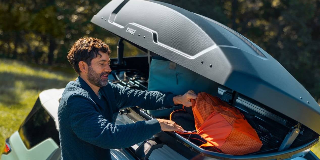image of a man loading accessory roof storage on a 2025 Chevrolet Equinox