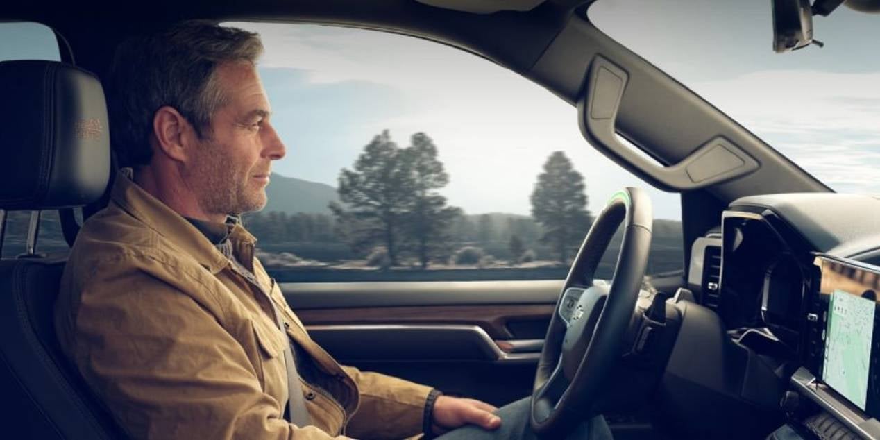 guy driving his 2025 Chevrolet Silverado without his hands on the steering wheel