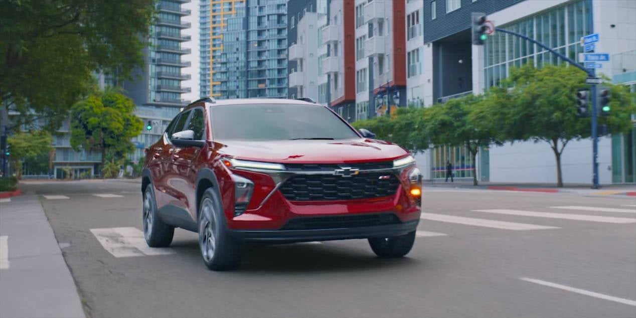 crimson red 2025 Chevrolet Trax making a left hand turn in a city