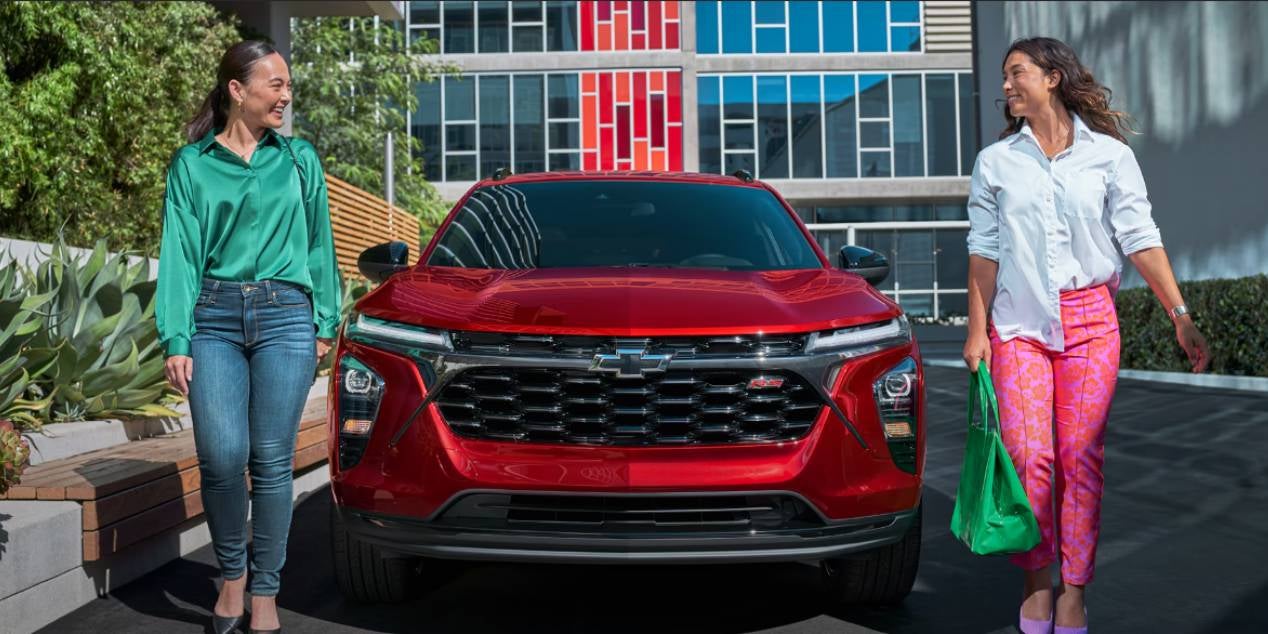 2 women parked and walking towards the front of their 2025 Chevrolet Trax